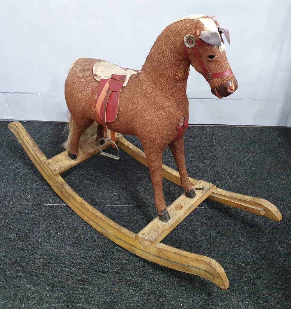 a small rocking horse with straw fill on painted wooden base c1930
